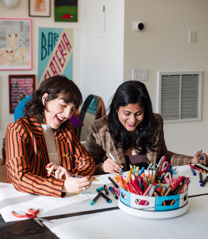 Close up of Piera and Lakshmi's hands with art supplies